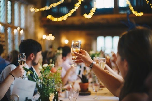 People seated at an elegant table raising glasses of Champagne for a toast